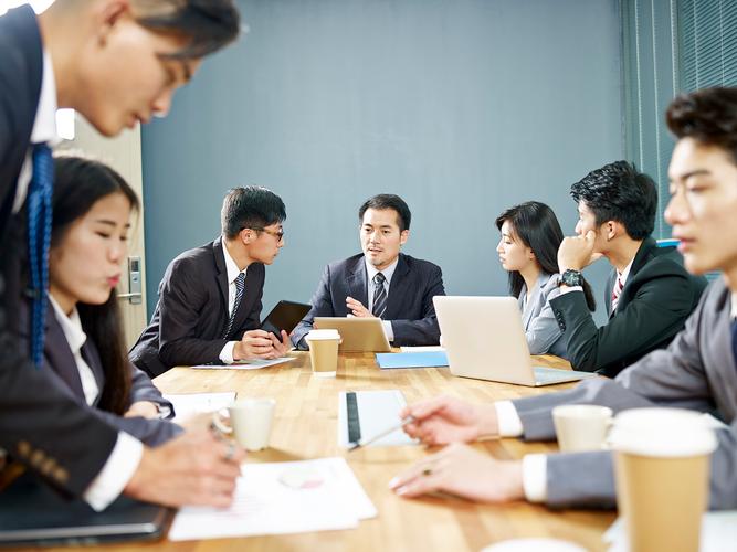 商务人员团队使用笔记本电脑在办公室开会谈论